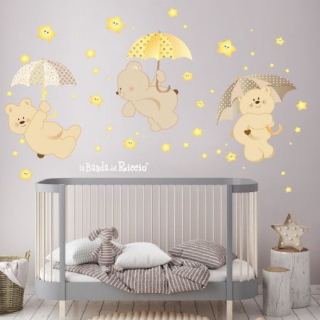 Adesivi murali "Pioggia di Stelle" tre orsetti con ombrelli e stelline che si illuminano al buoi. Colore beige. Foto ambientata.